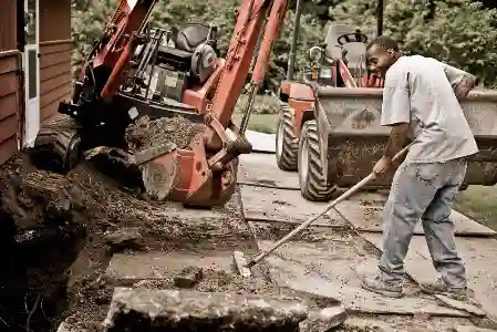 McCoy Contractors foundation repair crew sweeping as team excavates exterior basement wall Milwaukee