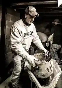 McCoy Contractors foreman mixing concrete in basement during foundation repair work Milwaukee