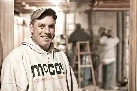 McCoy Contractors foreman smiling in basement with full foundation repair crew working Milwaukee