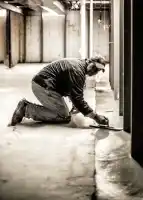McCoy Contractors, Inc. - Working concrete in basement with trowel